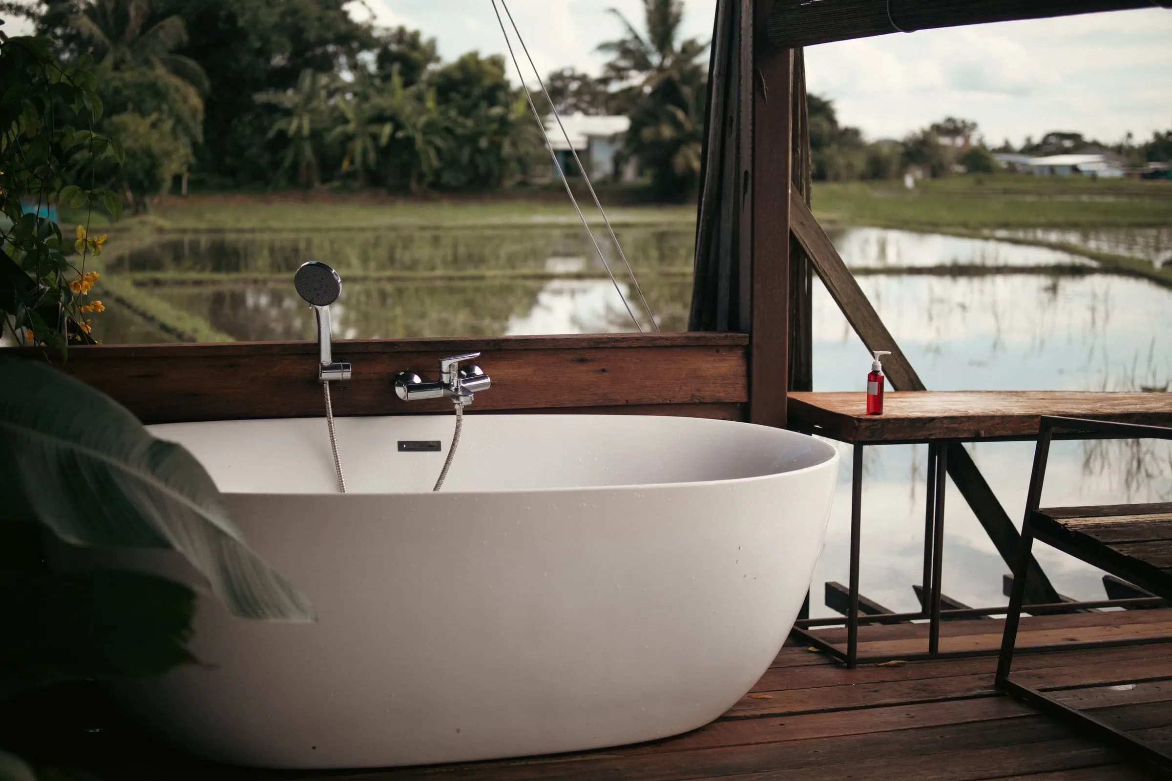 Outdoor bathtub on a deck facing rice fields