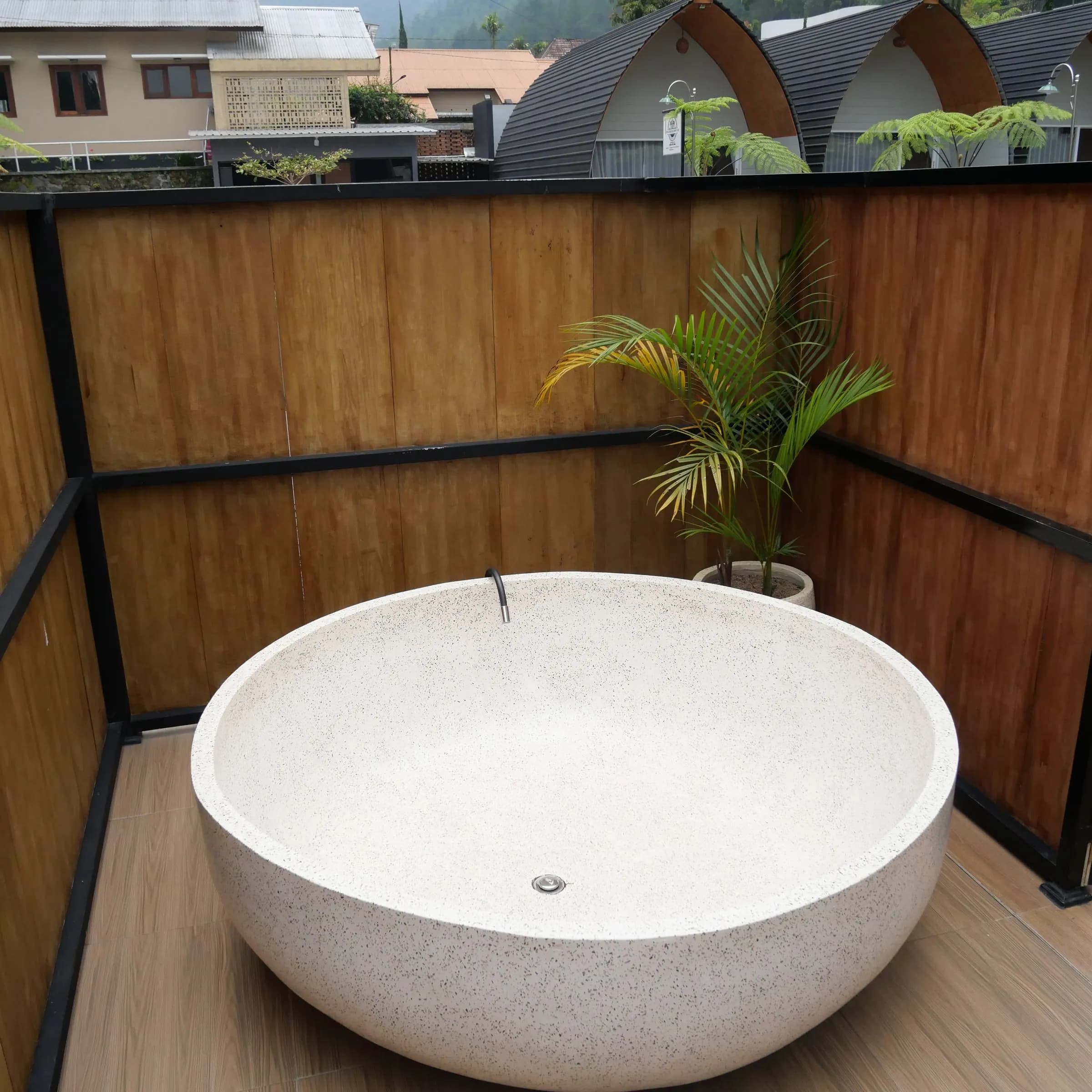 Round stone bathtub on a timber deck